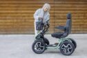 woman standing beside a scooter
