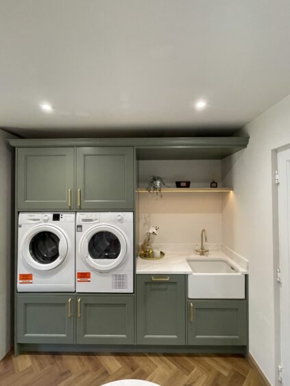 utility area equipped with washer, drier and sink