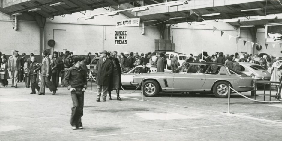 people walking around the cars