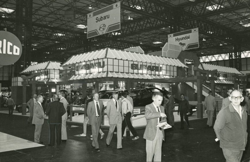 people walking in front of the he Subaru and Hyundai stand at the Dundee Motors Show in 1984.