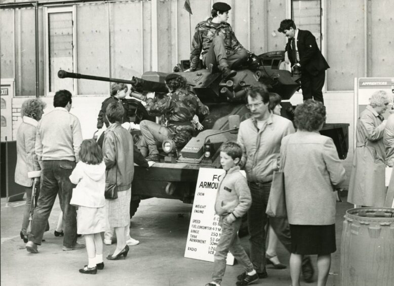 people climb up to look at an armoured car in May 1985