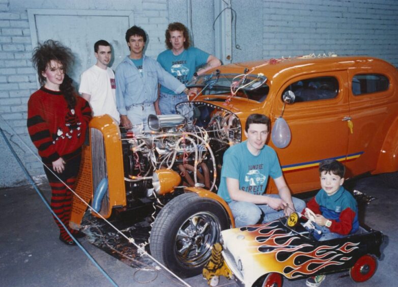 Members of the Dundee Street Freaks with the 1936 Ford Pilot. A little boy sits inside a pedal car designed like a hot rod