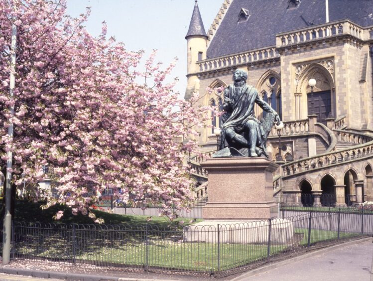 a pink-flowering tree sits the Robert Burns statue outside Dundee's McManus Galleries in 1988. 