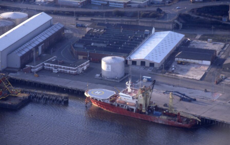 an aerial shot shows warehouses and a boat docked at Dundee harbour 