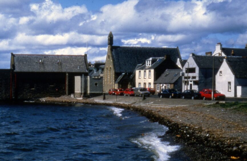 A view along Fisher Street in Broughty Ferry, with the River Tay coming up to the sea wall