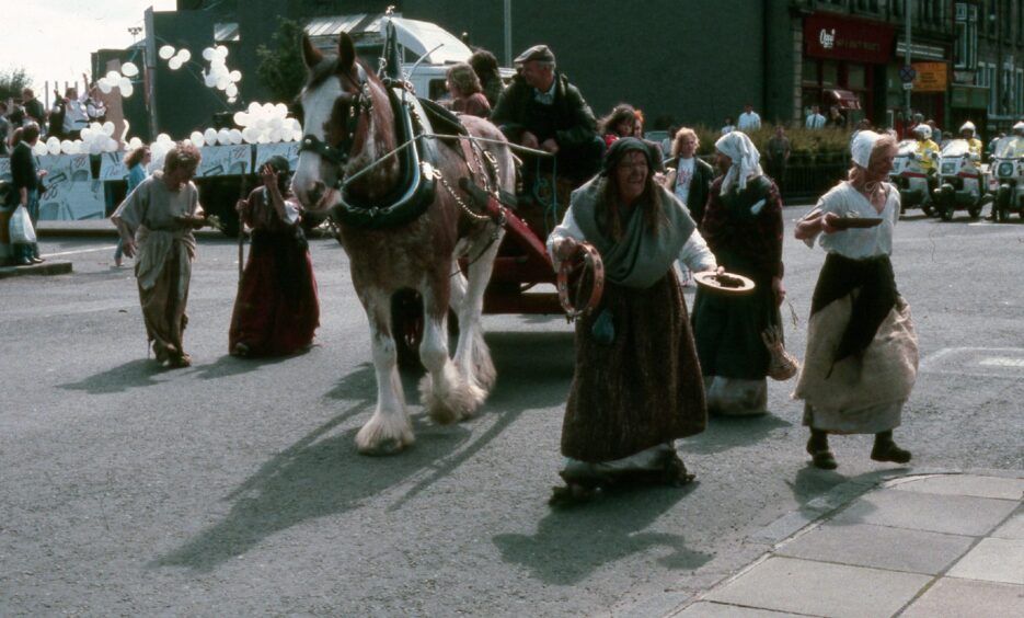 A horse and cart walk through Dundee streets.