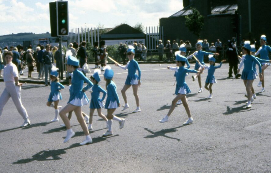 Majorettes twirl batons in the streets of Dundee.