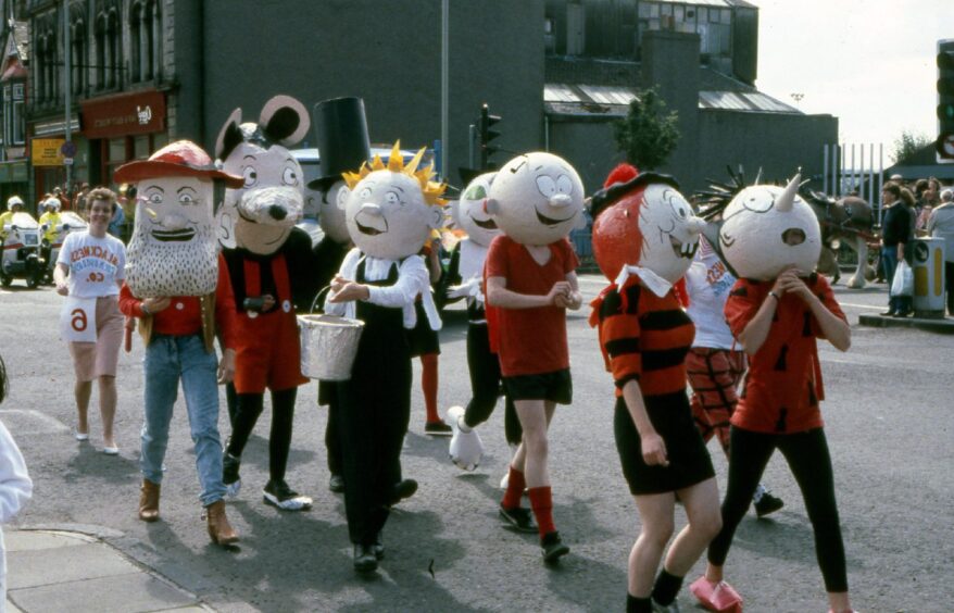 Comic characters - people in fancy dress, partying in the streets.