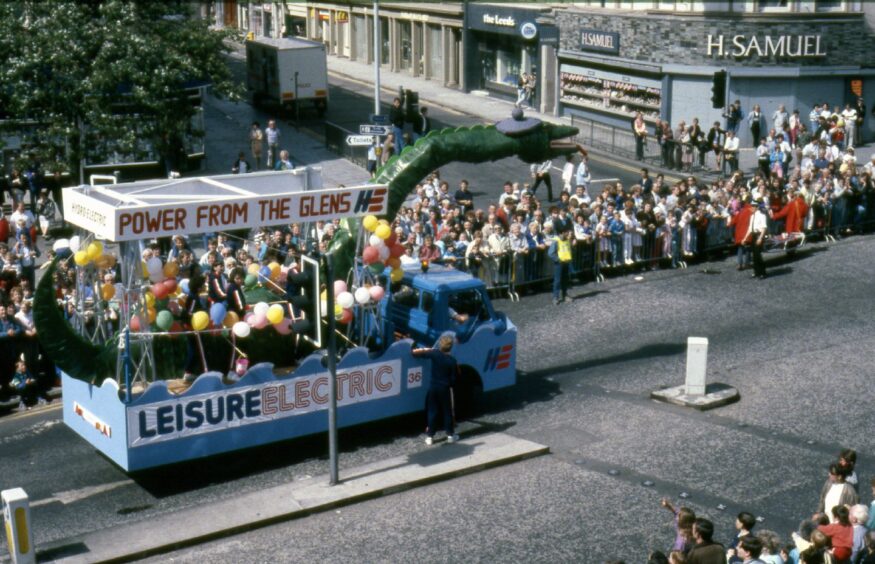 Crowds line the street as a float approaches Samuel's Corner on the High Street in July 1988 during the Dundee Festival parade.