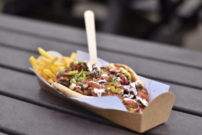 A shawarma sitting in a box on a table.
