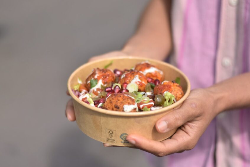 A woman holding a falafel salad.