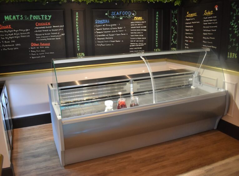 An empty fish and seafood counter, located in a restaurant.