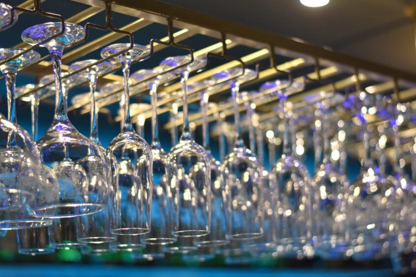 Rows of clean glasses hanging up in 1876.