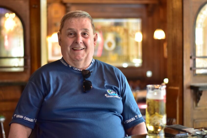 A man smiling in a pub.