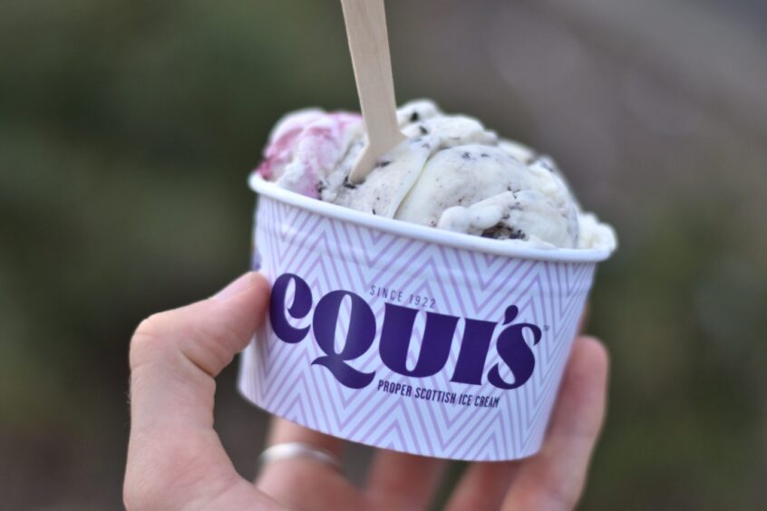 A person holding a tub oof Equi's