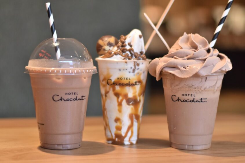 An iced chocolate drink, a sundae and a chocolate shake all lined up beside one another.