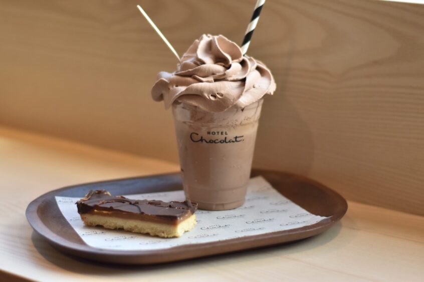 A millionaire's shortbread and a chocolate shake sitting on a serving tray.