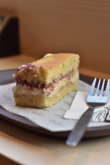 A slice of Victoria sponge cake served on a tray.