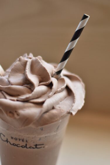 A close up image of the cocoa whip topping on a chocolate shake.