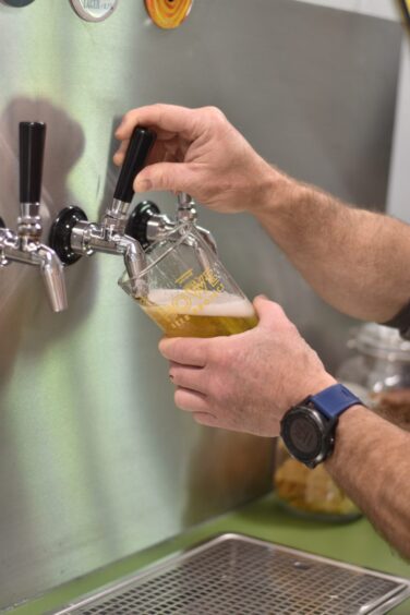 A person pouring a beer.