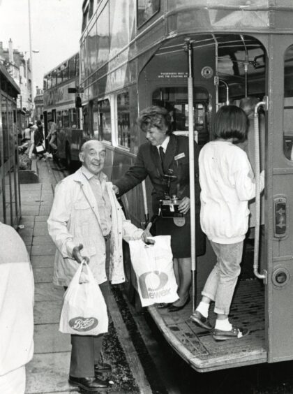 Bus conductor Agnes McIntosh with a passenger in Dundee. 