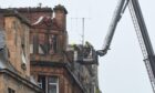 Firefighters inspect the scene of the blaze on Scott Street in Perth. Image: Stuart Cowper