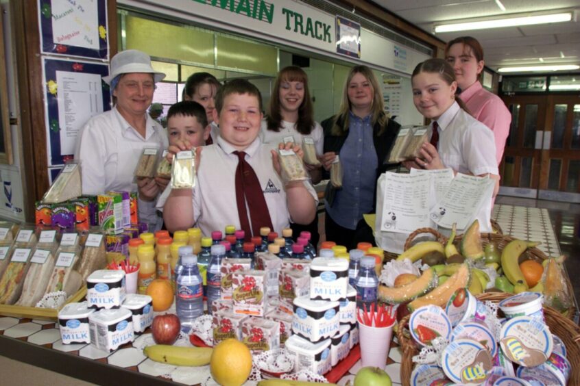 Supervisor Sandra McInnes and pupils with the food spread out on a table