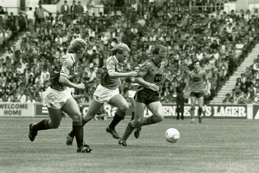 Eamonn Bannon on the ball as two Rangers players give chase
