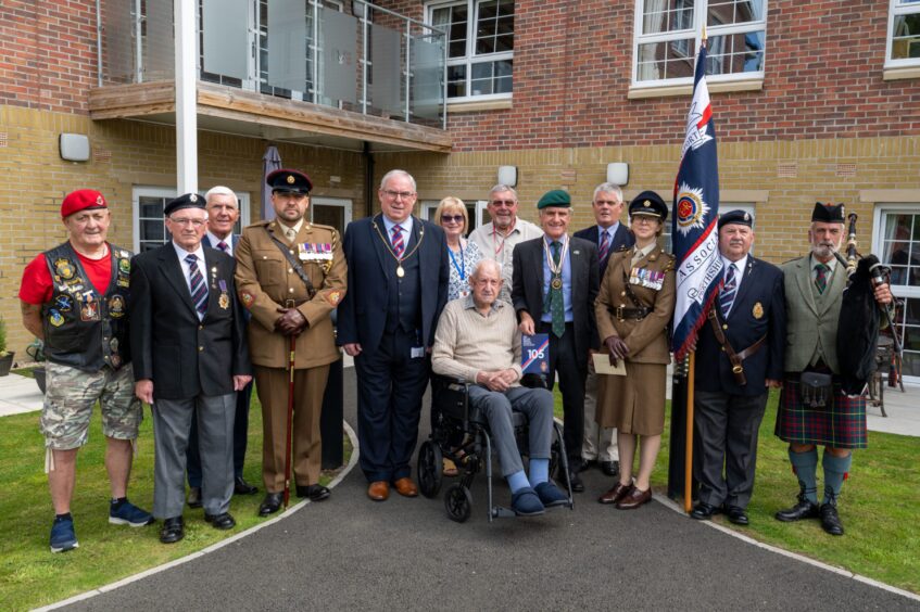 Walter Smith, seated in wheelchair, with group of people around him, some in uniform