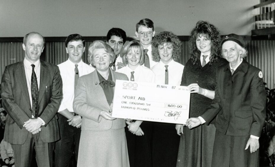Pupils and officials at a presentation of a cheque to Sport Aid.