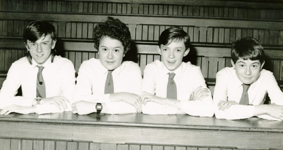 Four op of the Bench competition pupils seated behind a desk.