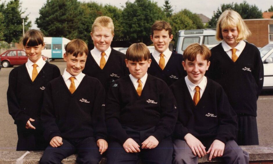 Pupils model their new school wear in the car park. 