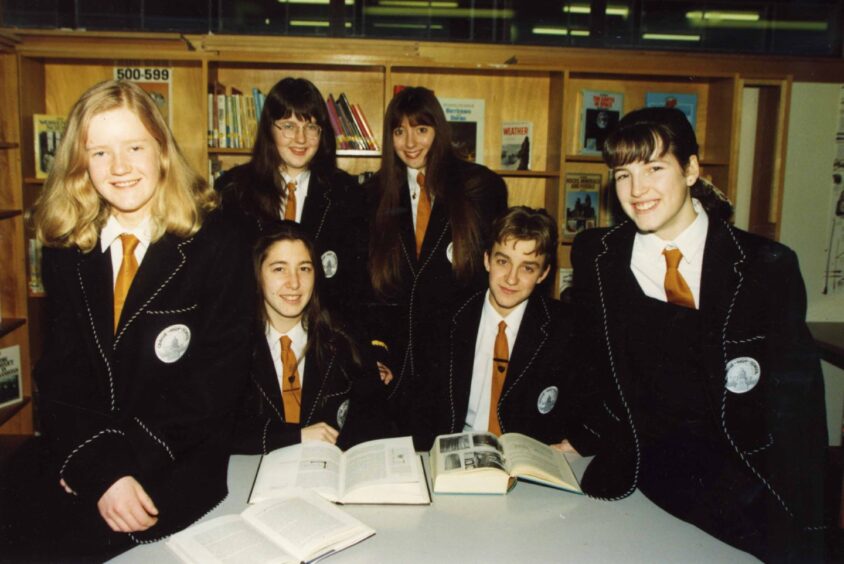 Prefects gather around a table to pose for the camera.