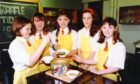 Four pupils of Craigie High School, Dundee, who ran a soup kitchen to raise money for Children in Need. They are wearing aprons and a pot of soup and bowls sits on a table in front of them.