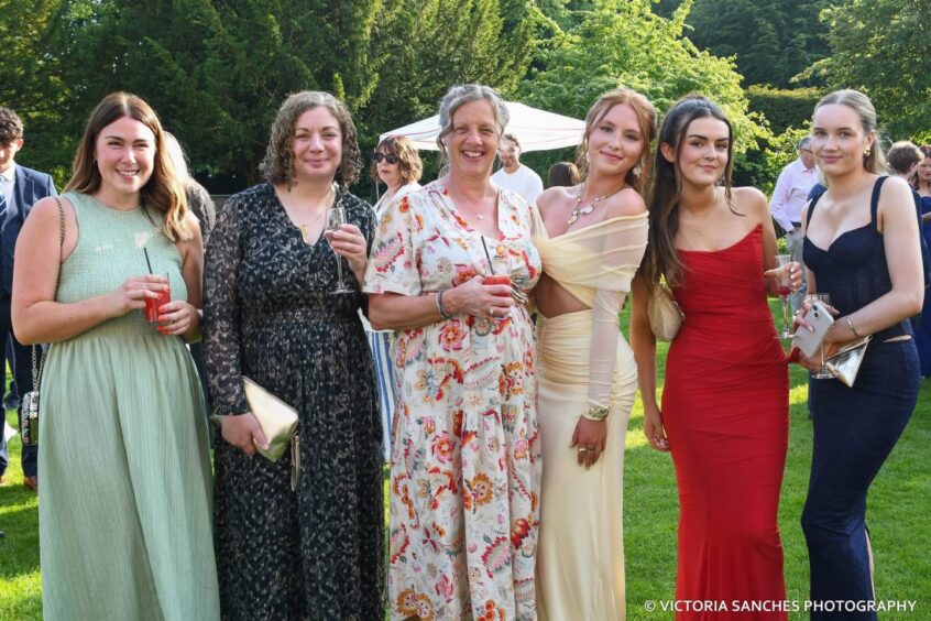 Teachers pose with departing pupils. 
