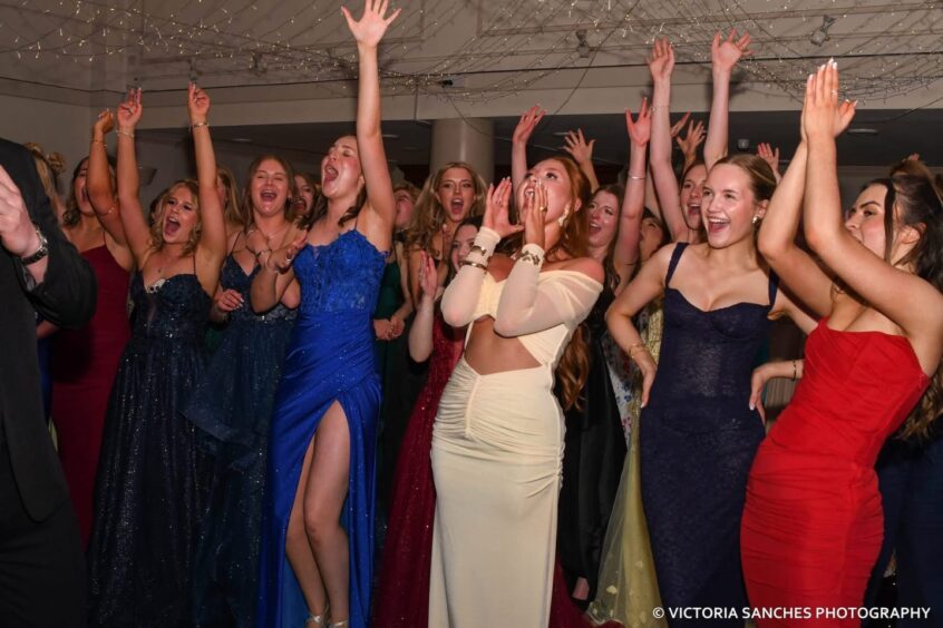 Girls throwing their hands up in the air. 