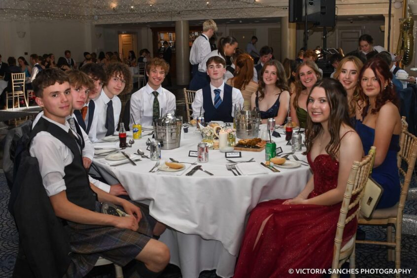 Girls and boys sitting at a circular table. 