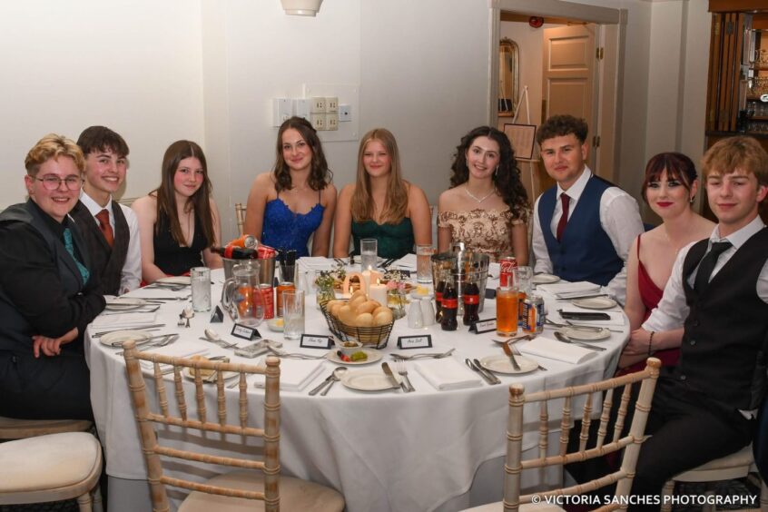 Girls and boys sitting at a circular table. 