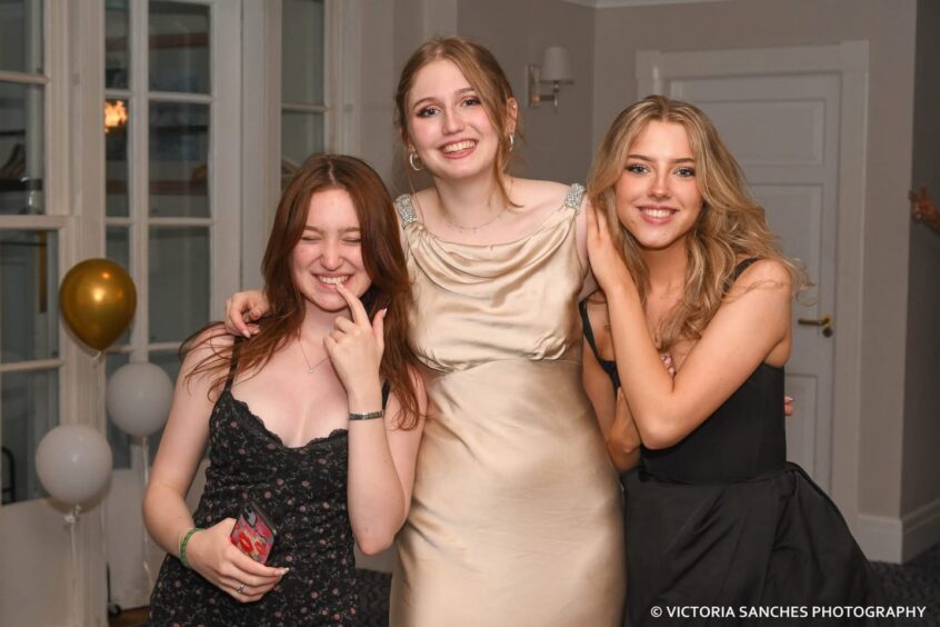 Elegantly dressed girls share a laugh. 