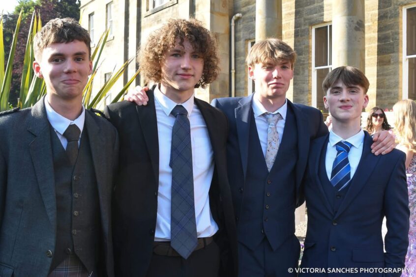 Four boys smiling at at Bell Baxter High School's class of 2025 prom. 