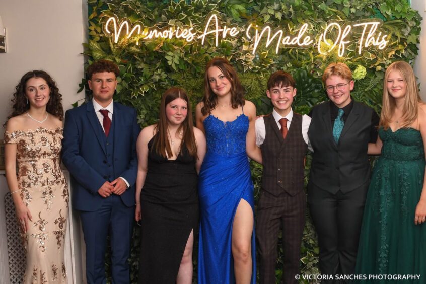 Departing pupils beneath a neon sign that reads "Memories are made of this".