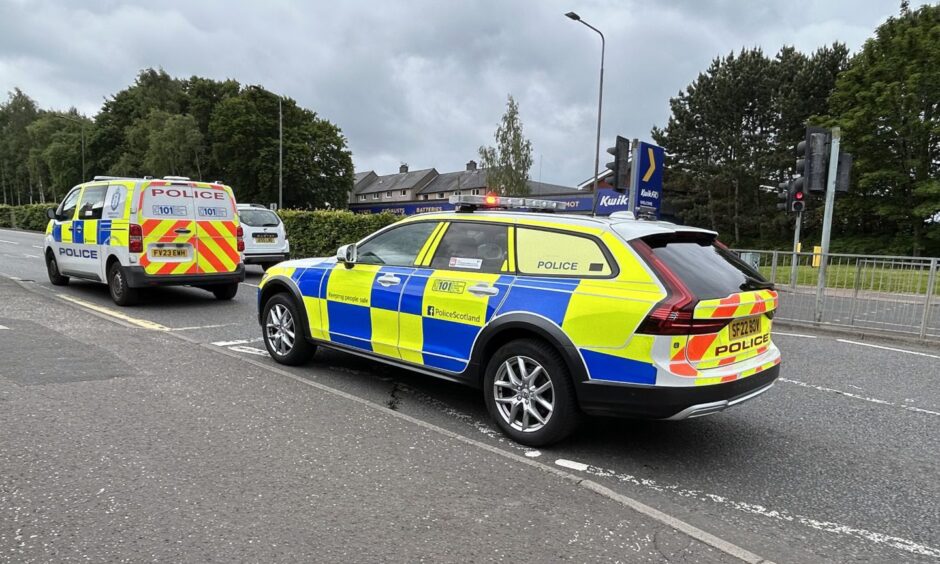 A police car and van on a road