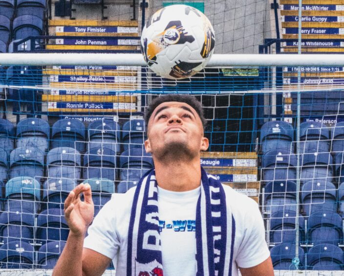 Jai Rowe, wearing a Raith Rovers scarf, looks up as he heads the ball.