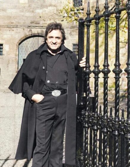 Johnny Cash, dressed all in black, at the gates of Falkland Palace in October 1981. 