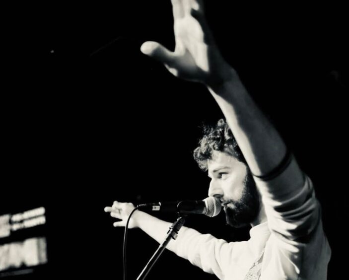 Black and white photograph of Dundee musician Josh Moncrieff on stage.