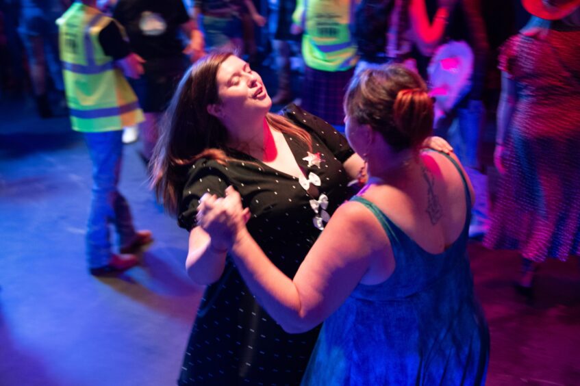 Two women dancing in a nightclub. 