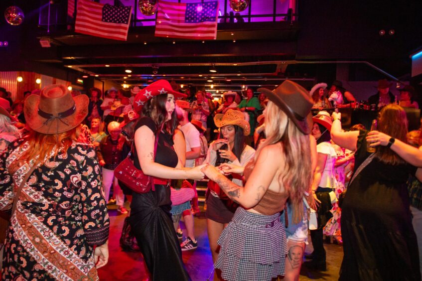 Country music fans dancing in a nightclub. 