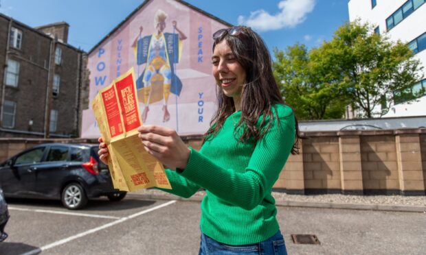 Poppy Watson studies a map of the Open/Close Dundee city centre street art trail.
