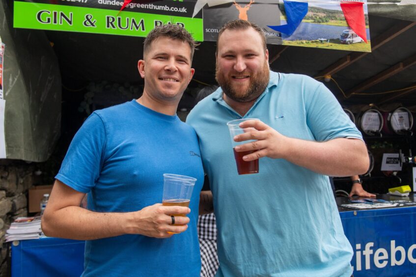 Two men clutching drinks at the Fisherman's Beer Festival.