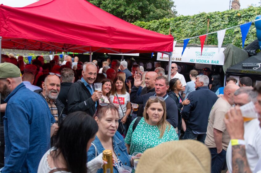 People drinking and chatting at a beer festival. 